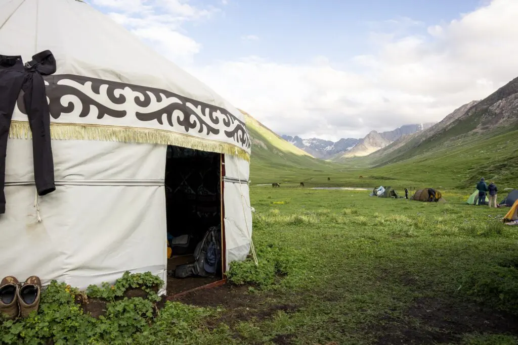 Yurt and tents in a lush mountain valley in Kyrgyzstan