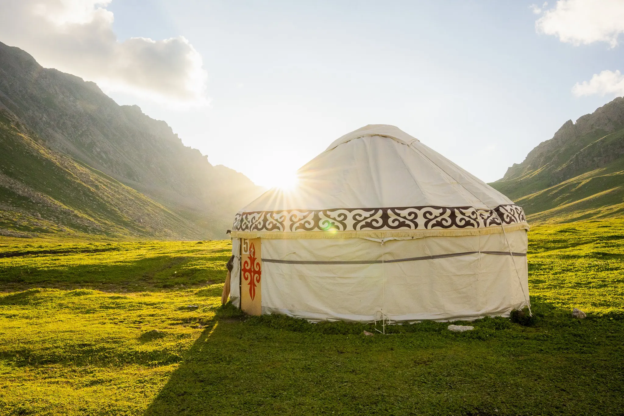 traditionele joert in een groene bergvallei bij zonsondergang