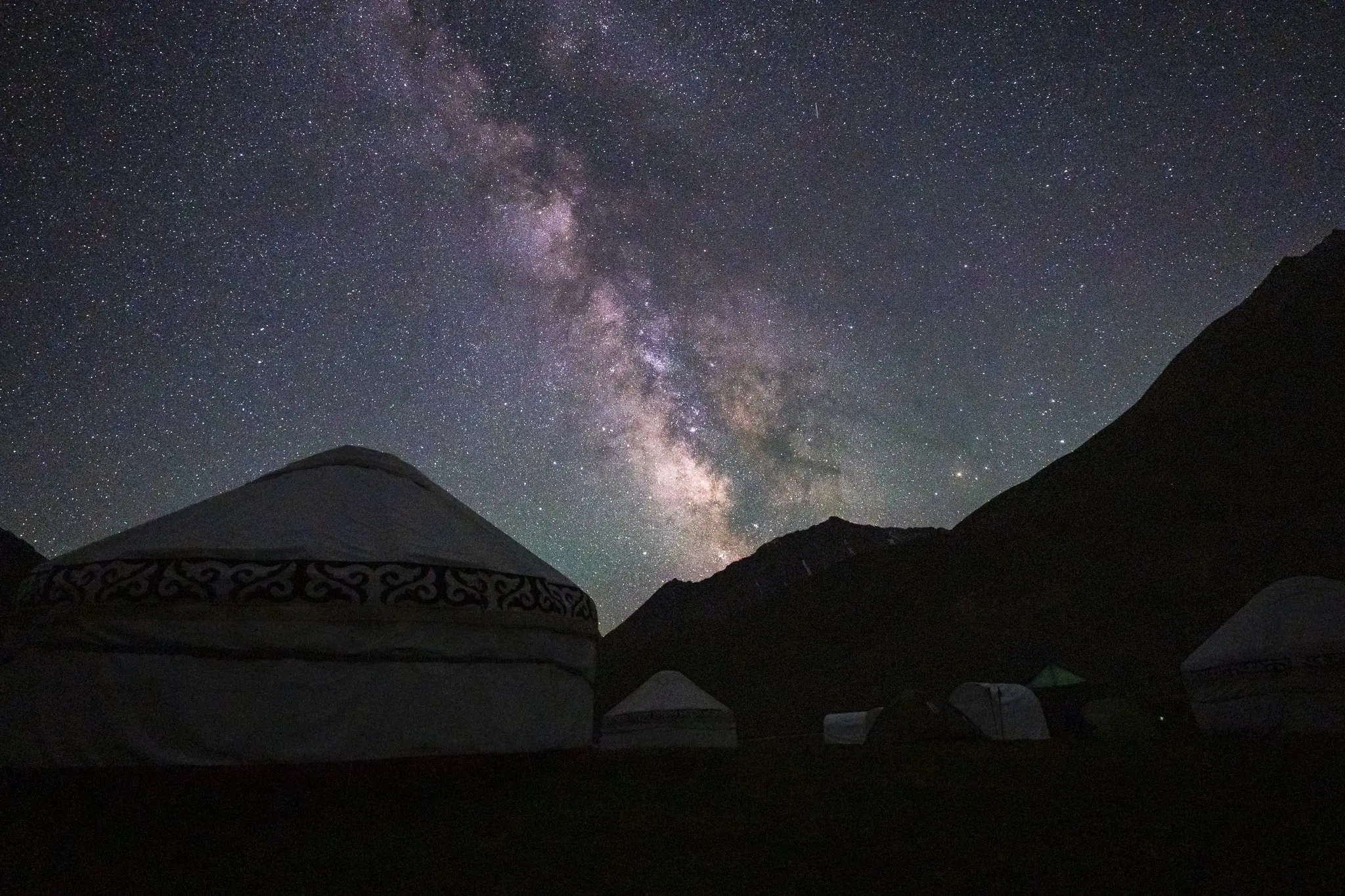Voie lactée au-dessus d'un camp de yourtes et des montagnes du Kirghizistan