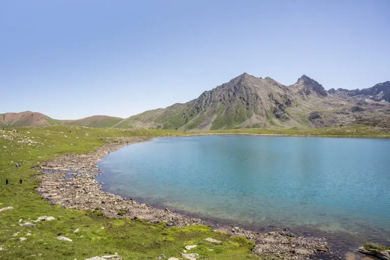 Randonneurs au bord d'un lac de montagne turquoise au Kirghizistan