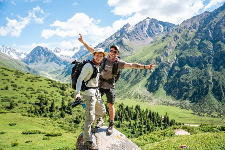 Two hikers posing on a rock in a mountain valley